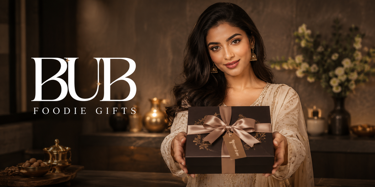 BUB Foodie Gifts collection banner with an elegant Indian woman presenting a premium boxed food gift in a warm luxury kitchen setting.