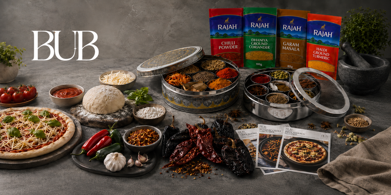 BUB spice tin collection with Rajah spices, Mexican dried chillies, pizza ingredients and recipe bundles displayed on a modern monochrome kitchen surface.